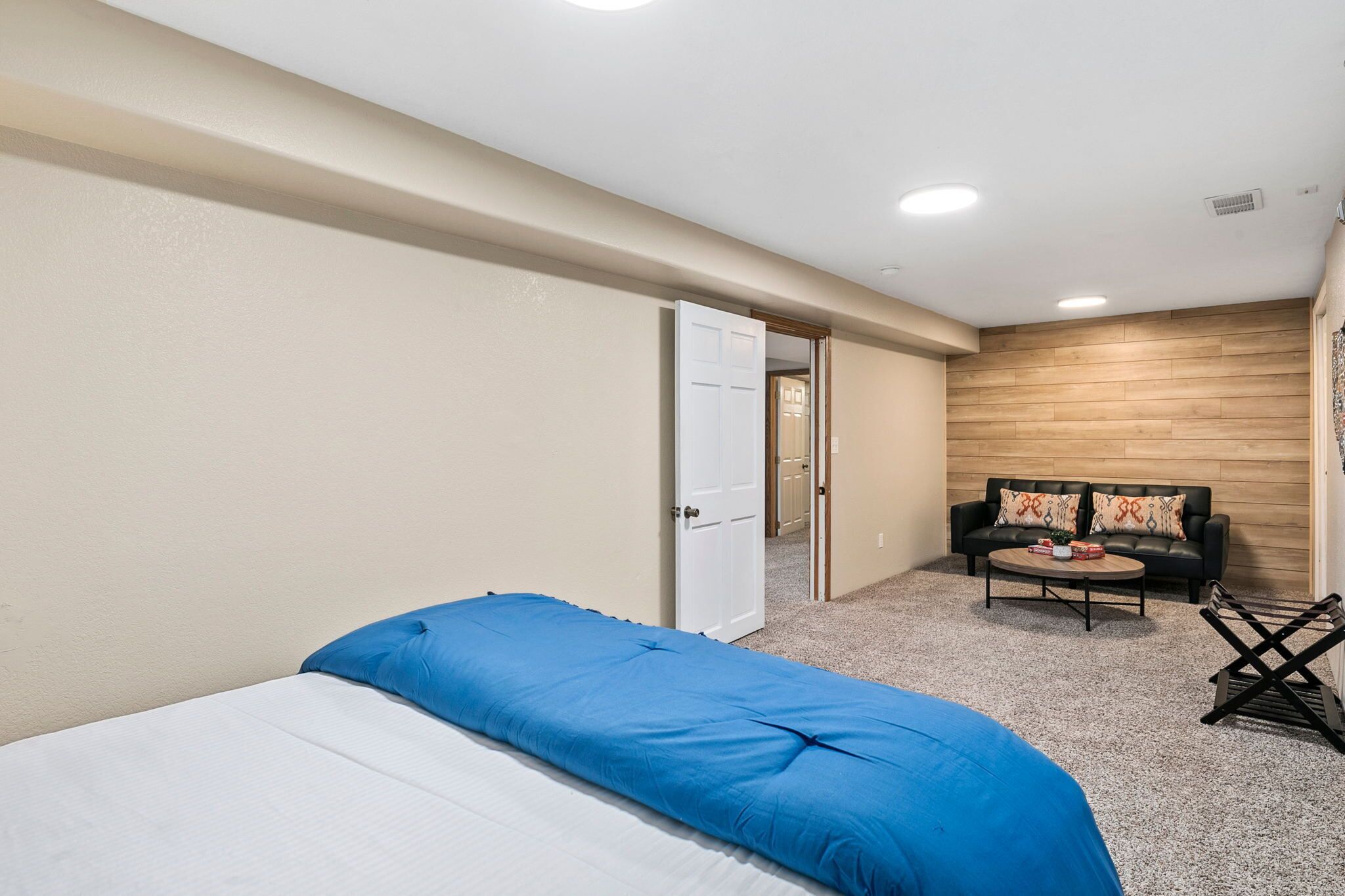A bedroom with a bed, a sofa, and a small table.