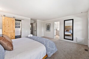 Cozy retreat with a large bed, wardrobe, and dresser, perfect for a restful stay.