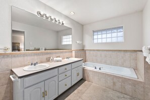 Enjoy a refreshing bath in the spacious bathtub and get ready with dual sinks and ample lighting.