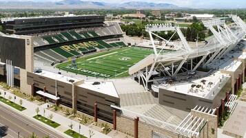 A football stadium with a large seating area, a field, and a modern architectural design.