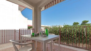 A balcony with a white table and chairs, a red railing, and a view of trees and buildings. - 3150 Villa Giovì - Appartamento 2 by Barbarhouse (Manduria)