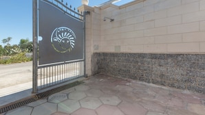 A gated entrance with a decorative metal gate, a tiled wall, and a hexagonal tile floor. - 3150 Villa Giovì - Appartamento 2 by Barbarhouse (Manduria)