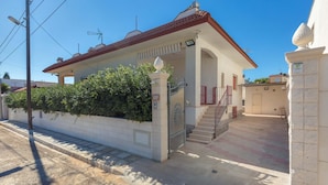 A two-story building with a red-tiled roof, a white exterior, and a gated entrance. - 3150 Villa Giovì - Appartamento 2 by Barbarhouse (Manduria)
