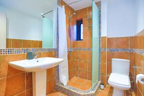 A bathroom with a shower, sink, and toilet.