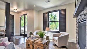 A modern living room with a sofa, armchairs, a coffee table, and a fireplace.