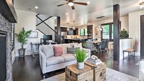A spacious living area with a modern sofa, a coffee table, and a ceiling fan.