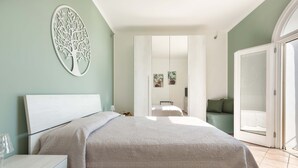 A bedroom with a large bed, a bedside table with a lamp, and a wardrobe. - 3135 La Voce del Mare by Barbarhouse (Nardò)