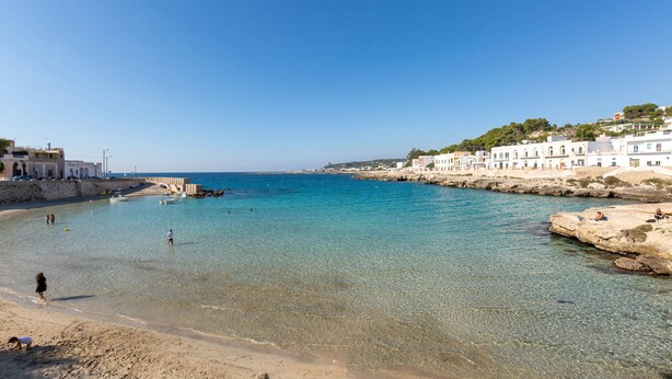 A coastal town with clear blue waters, sandy beaches, and white buildings along the shore. - 3135 La Voce del Mare by Barbarhouse (Nardò)