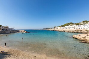 A coastal town with clear blue waters, sandy beaches, and white buildings along the shore. - 3135 La Voce del Mare by Barbarhouse (Nardò)