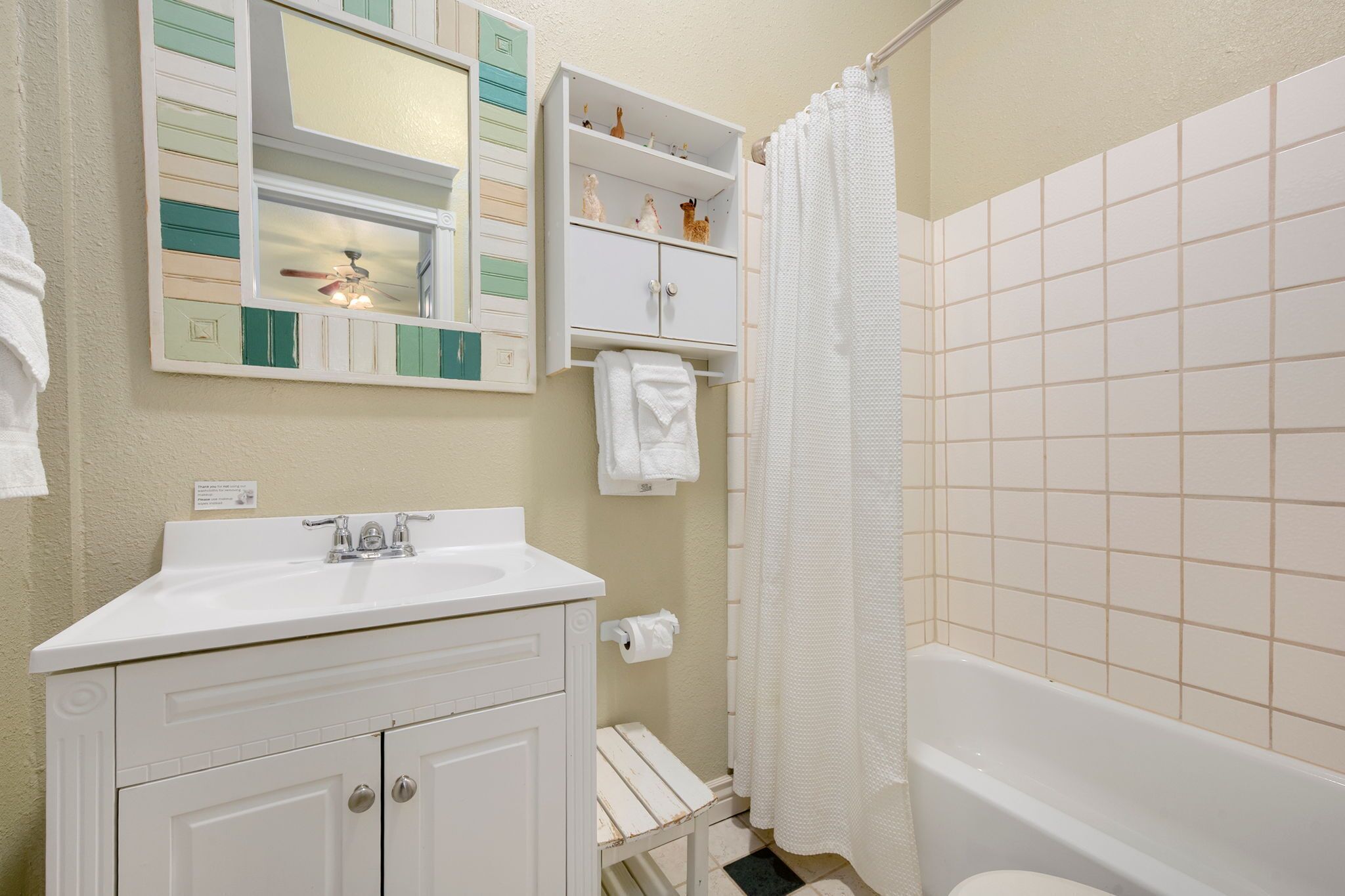 Un baño con lavamanos, tocador y bañera blancos.