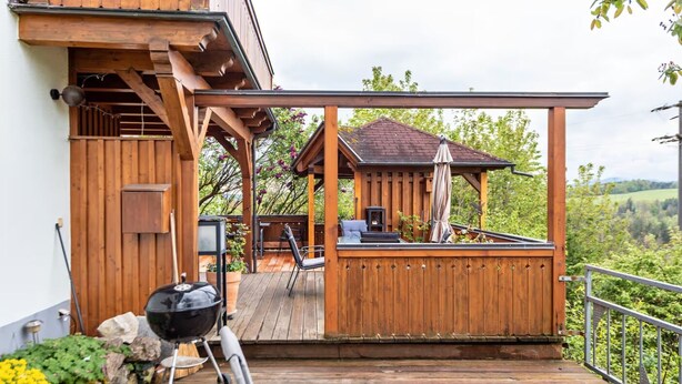 A wooden deck with a grill, outdoor furniture, and a view of the countryside. - Vacation apartment at Fuchsbühl  (Schopfheim)