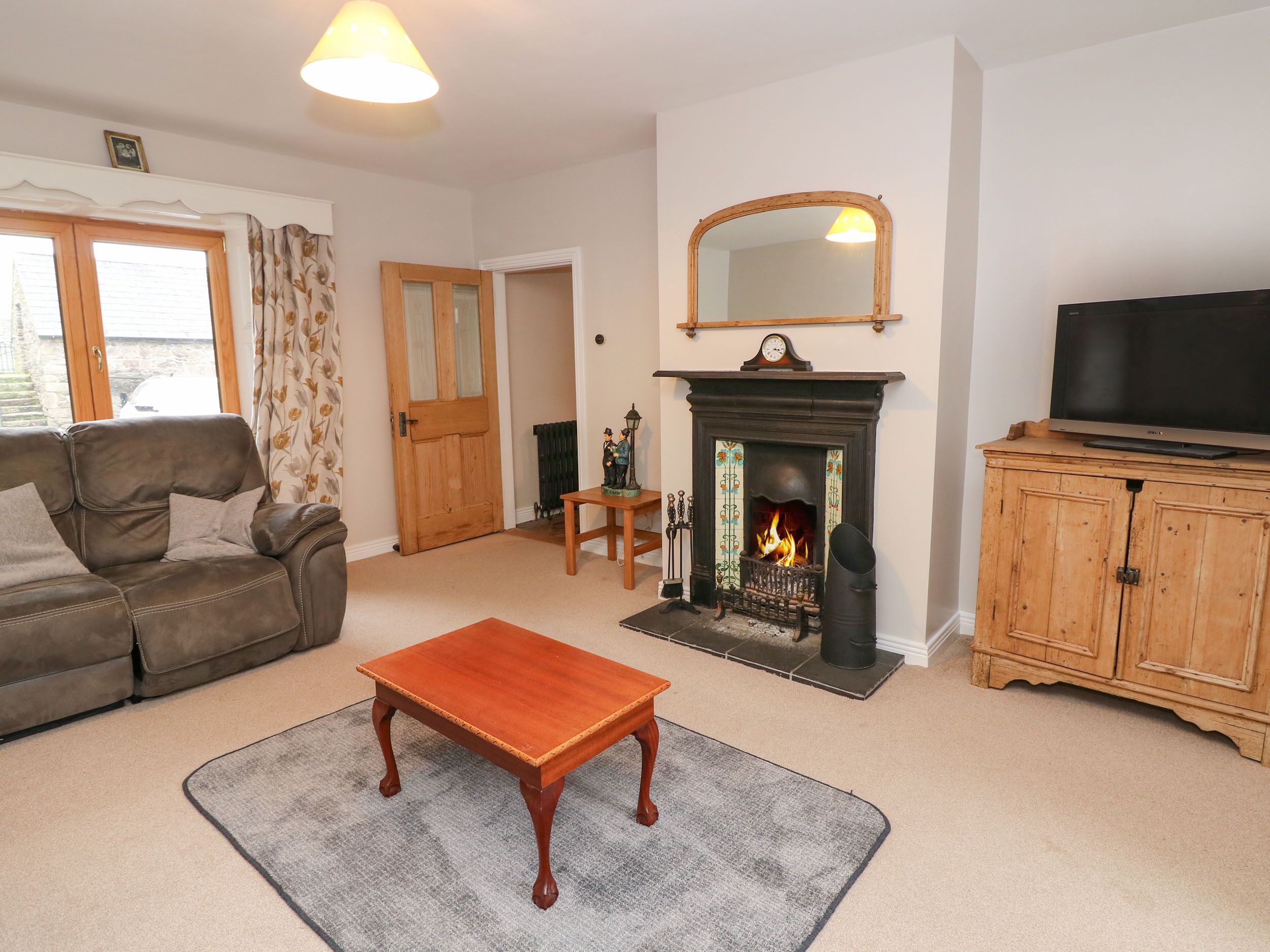 A living room with a fireplace, a sofa, a coffee table, and a television.