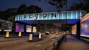 A street scene with a large illuminated sign reading "ACTON" above the road. - Studio Sleeps 1 Near Acton Park (London)