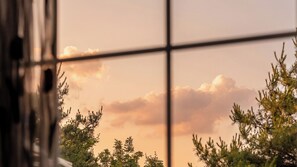 A window with a view of trees and a sunset sky. - Gapyeong Monami spa Pension (Gapyeong)