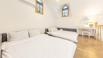 A bedroom with two beds, a desk, a chair, and a mirror.
