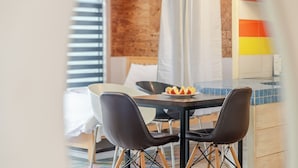 A hotel room with a dining area featuring a table, chairs, and a plate of fruit. - Gapyeong Monami spa Pension (Gapyeong)