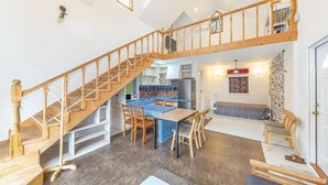 A spacious loft with a wooden staircase, a dining area, and a kitchen. - Gapyeong Monami spa Pension (Gapyeong)