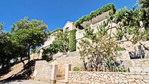 A stone staircase leading to a building with a balcony, surrounded by greenery and trees. - Oasis of Peace (Korcula)