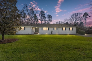 A single-story house with a front porch, a small front yard, and a driveway.