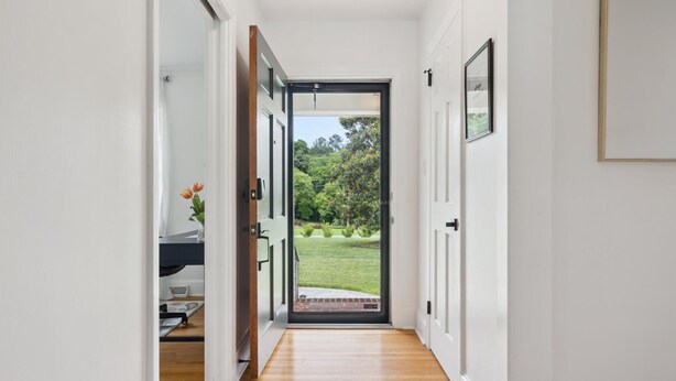 A hallway with a wooden floor leading to a glass door opening to a garden. - NEW! minutes to downtown - Private Half-Acre Ranch Retreat (Charlotte)