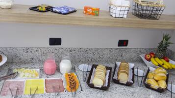 Uma mesa de buffet com diversos alimentos e acompanhamentos.