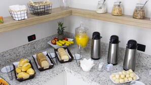 A breakfast buffet with bread, pastries, fruits, and juice. - NEO PARK HOTEL (Maringá)