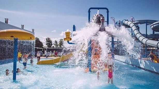 Parque acuático con un tobogán gigante y varias atracciones acuáticas.