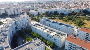 Un edificio residencial alto con varios pisos, techo plano y una zona de estacionamiento en la parte delantera.