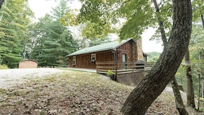 A rustic cabin with a wooden exterior, a porch, and a stone foundation. - Secluded, Great View! Hot Tub, Wood Fireplace, Screened in Porch, Arcade Games. (Rogers)