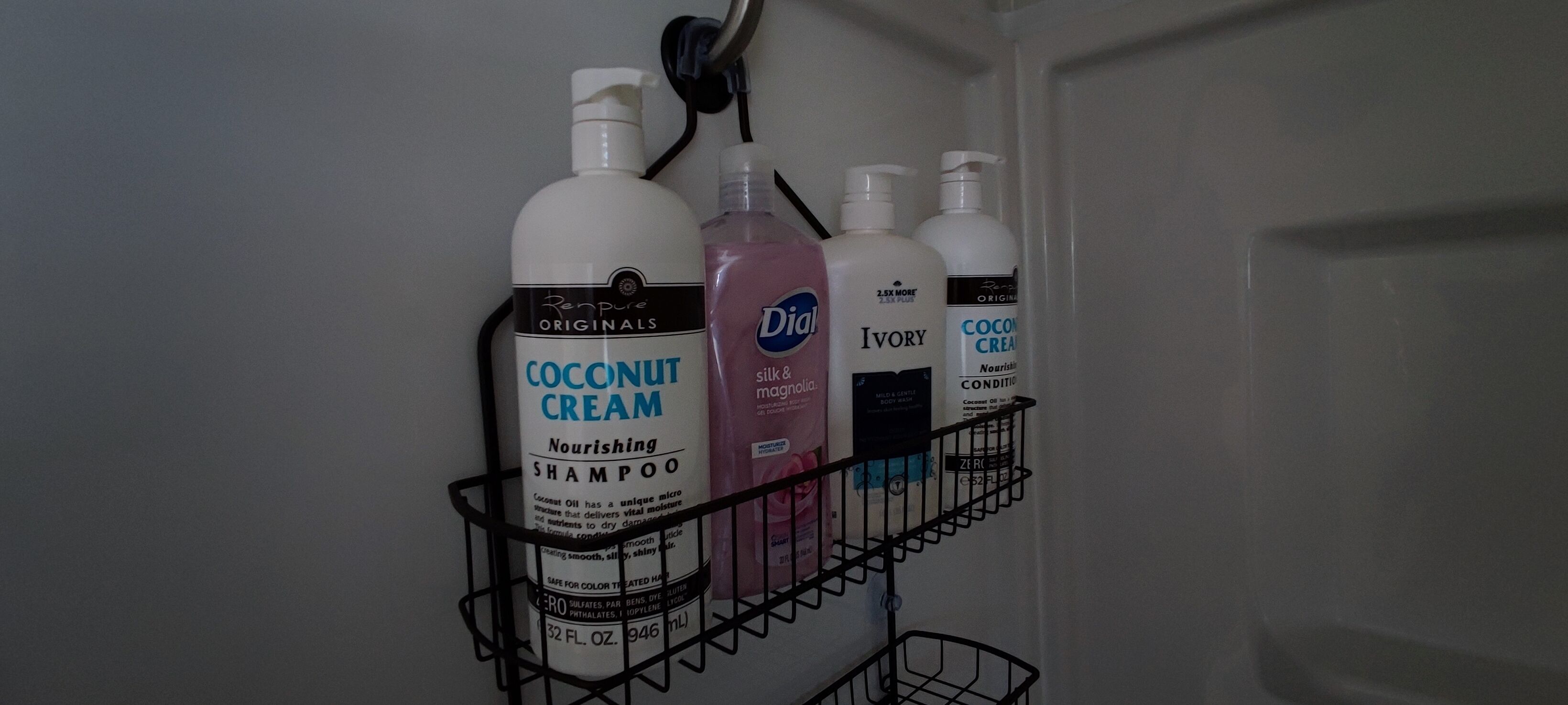 A bathroom shelf with various toiletries including coconut cream shampoo, Ivory soap, and Coco Creme body lotion.
