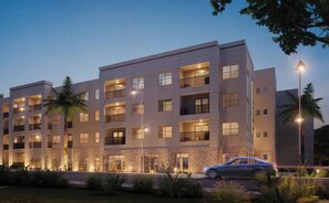 Stunning hotel building with balconies and windows, set amidst lush greenery and a well-manicured lawn.