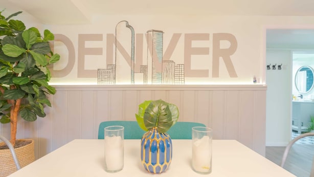 A hotel room with a city skyline mural, a potted plant, and two vases on the table. - Sloans Lake!  Walk to eateries/bars! Free parking! (Denver)