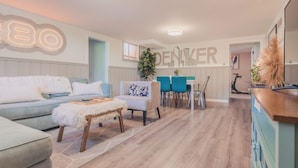 A modern living room with a sofa, chairs, a coffee table, and a dining area with a table and chairs. - Sloans Lake!  Walk to eateries/bars! Free parking! (Denver)