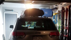 Un automóvil estacionado dentro de un garaje con nieve en el suelo.