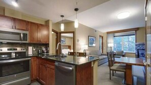 Una cocina moderna con electrodomésticos de acero inoxidable, armarios de madera y una isla central.