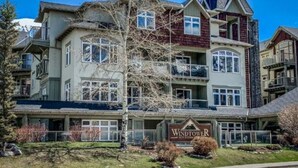 A multi-story building with a prominent sign reading "Windtowers." - BLUE BIRD SKIES - MOUNTAIN VIEWS - GYM & SECURE PARKING (Canmore)