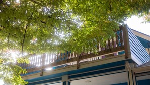 A building with a blue and white facade, a balcony with a white railing, and a sign that reads 'WINE.' - Downtown Studio w/Huge Balcony ·King Bed ·Walkable (Eugene)