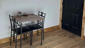 A dining area with a table and chairs, a window with a view, and a black door. -   Private Mtn Room 1/4 mi from Purgatory.  Perfect Base Camp! (Durango)