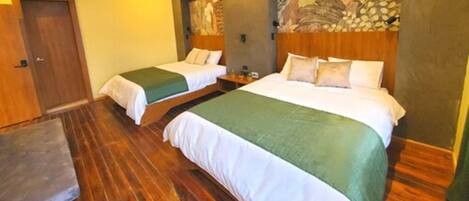 Une chambre d’hôtel avec deux lits, un plancher en bois et une fresque murale.