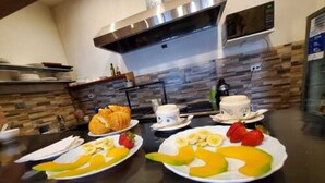 A breakfast buffet with plates of fruit, pastries, and coffee cups. - Hotel Inti Quito (Quito)
