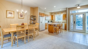A spacious kitchen with wooden cabinets, a central island, and a dining area with chairs. - HOT TUB, Eagle Crest Condo on Golf Course, DOGS OK (Redmond)