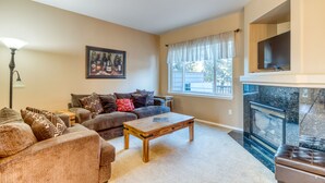 A living room with a fireplace, a sofa set, a coffee table, and a television mounted above the fireplace. - HOT TUB, Eagle Crest Condo on Golf Course, DOGS OK (Redmond)