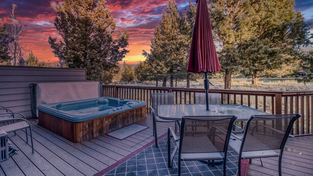 A deck with a hot tub, table, chairs, and an umbrella. - HOT TUB, Eagle Crest Condo on Golf Course, DOGS OK (Redmond)