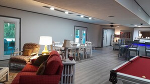 A spacious living area with a pool table, a dining table with chairs, a sofa, and a lamp. - Spacious, private retreat -  hot tub, firepit, pool table, dry sauna, patio (Oak Ridge)