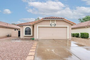 A residential house with a garage, a driveway, and a clear sky.