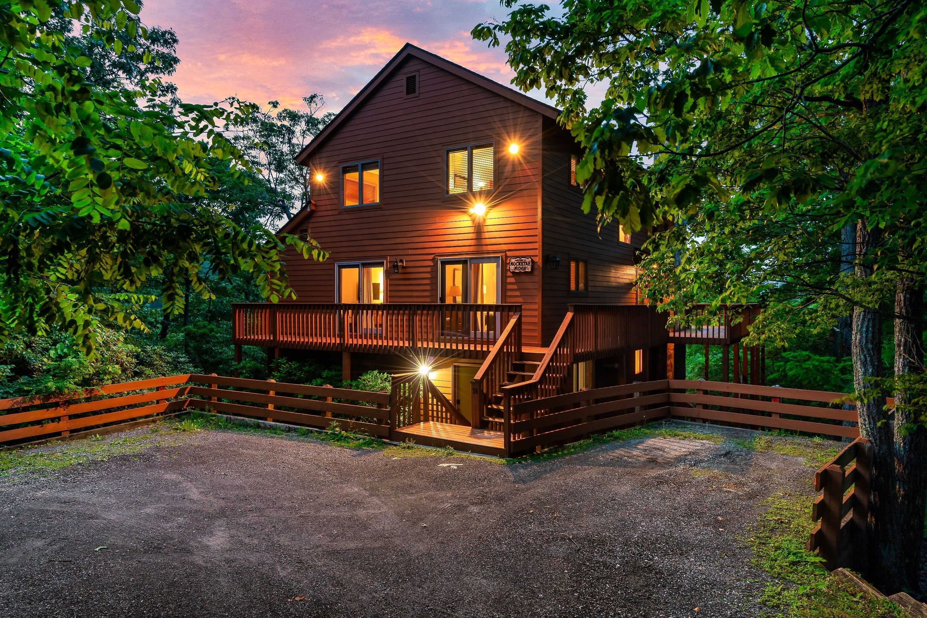 A two-story wooden house with a porch and a staircase leading to the upper floor.
