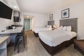 A hotel room with a kitchenette, two beds, a desk, and a chair. - Suburban Williamsburg (Williamsburg)