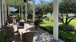 A covered patio area with wicker furniture and potted plants. - Heritage country luxury hotels close to wineries, concerts & restaurants (Leconfield)