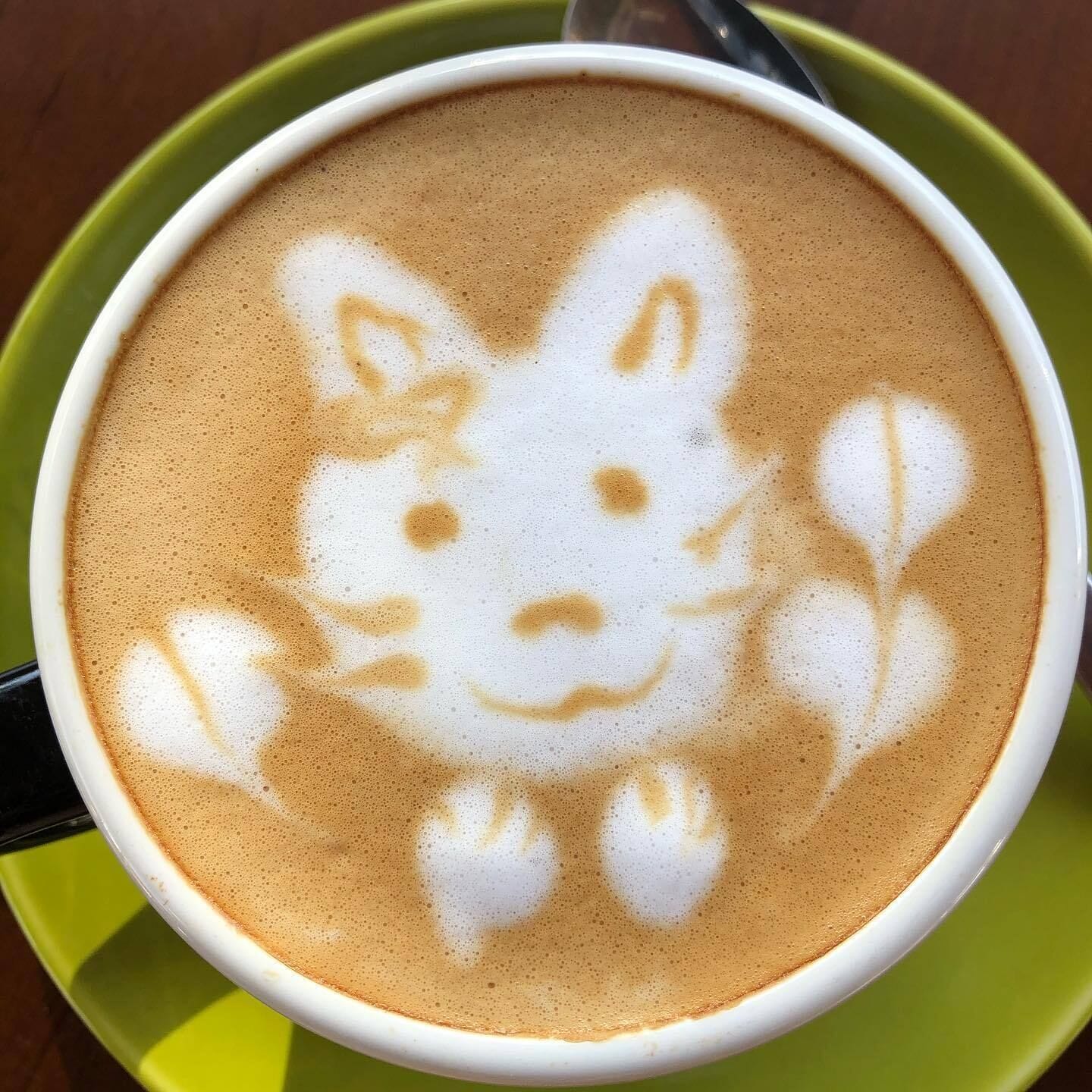 A cup of coffee with latte art of a cat.