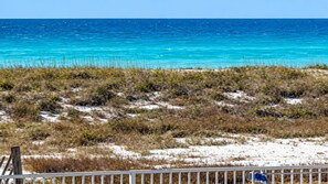 A coastal landscape with a sandy beach, sparse vegetation, and a clear blue sea. - BEACHFRONT -Paradise Found @ Summerwind- Owner-Managed - Beach Buggy - Beach Svc (Navarre)